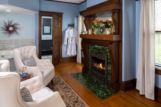 Suite Sitting area with fireplace, chairs, 2 person jetted tub, ensuite bath