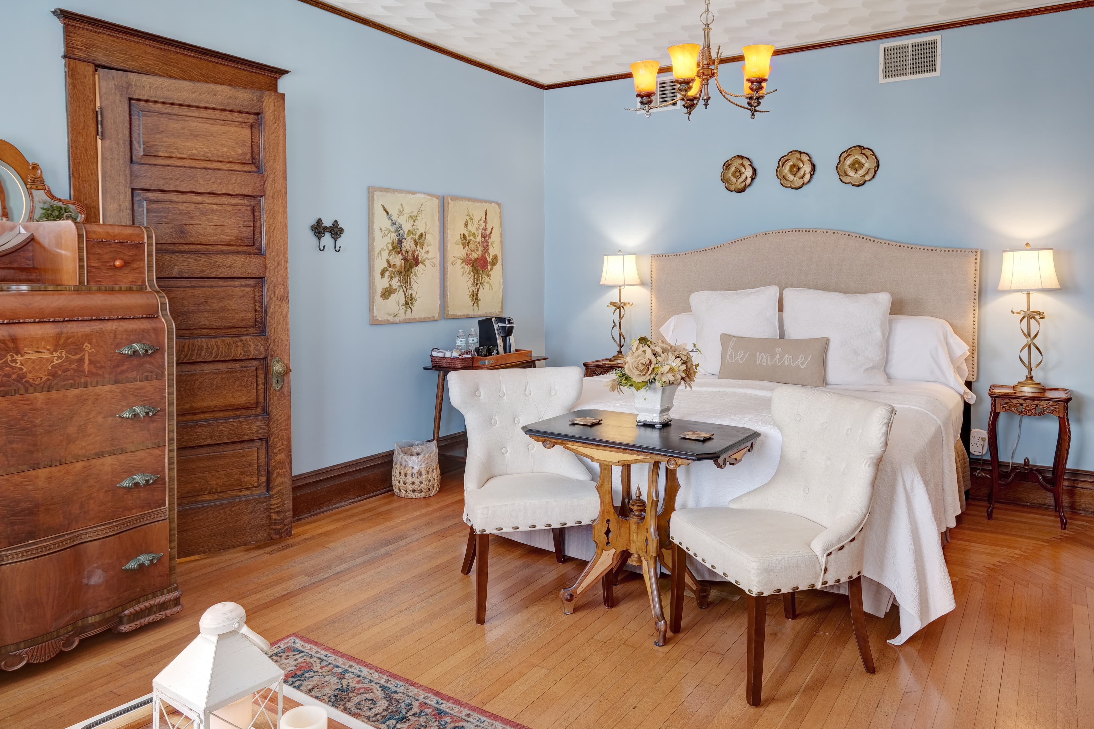 Suite with a king bed, antique furnishings, table/chairs and ensuite bath.