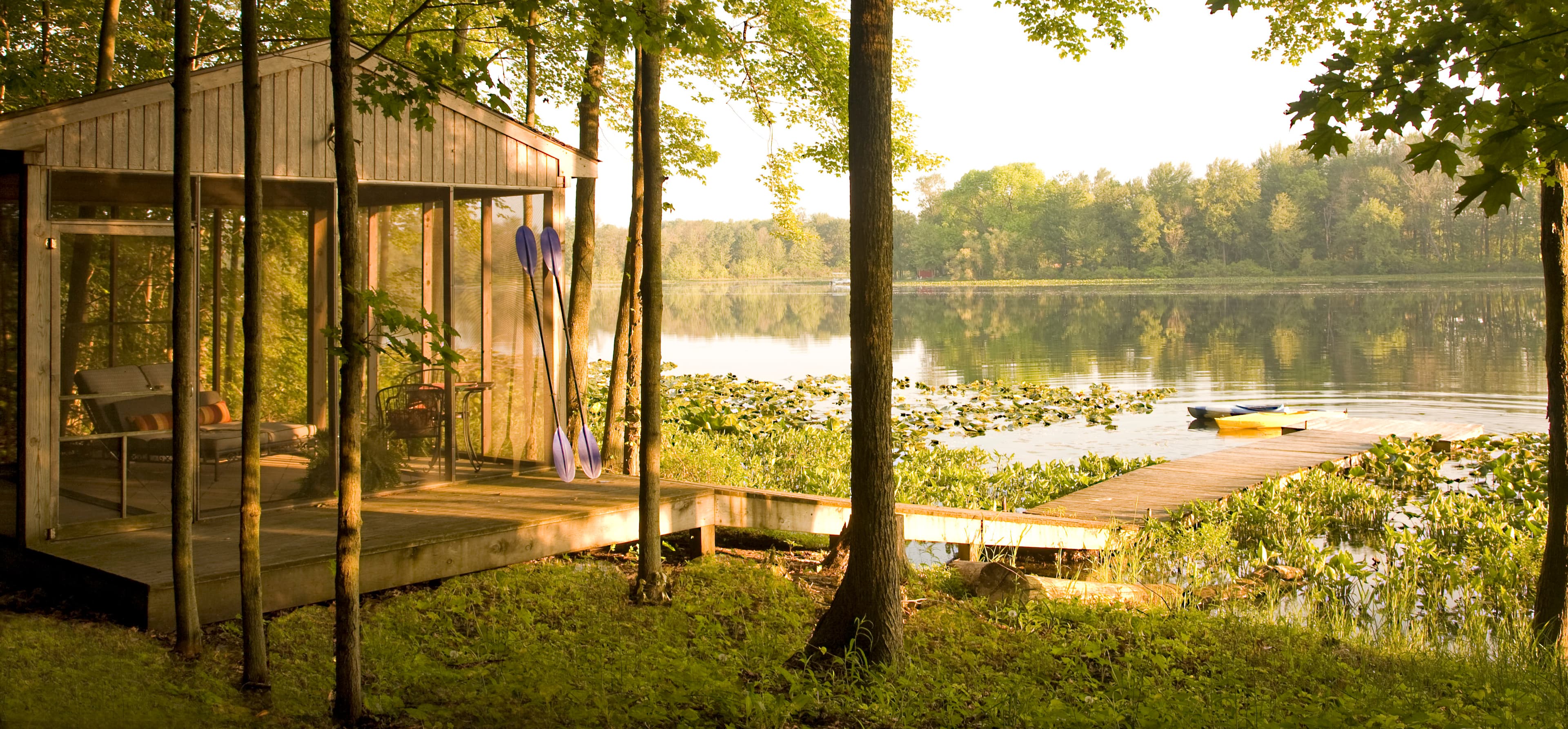 A cozy lakeside cabin surrounded by trees and a peaceful water view.
