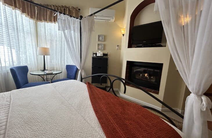 Rooms view from the king size bed, with seating area, fireplace and television.