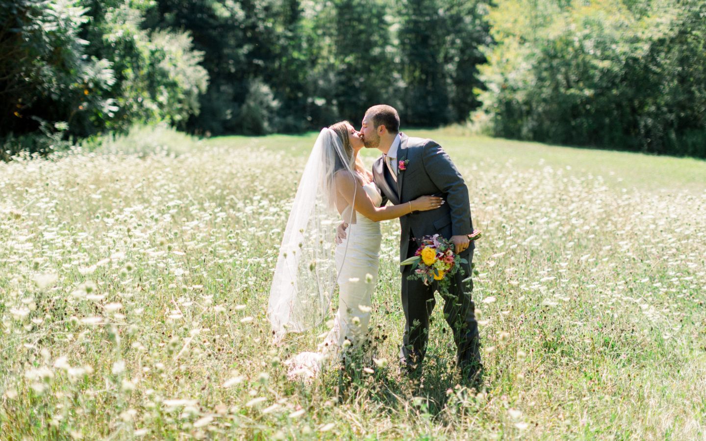 wedding couple kiss in the meadow at castle in the country