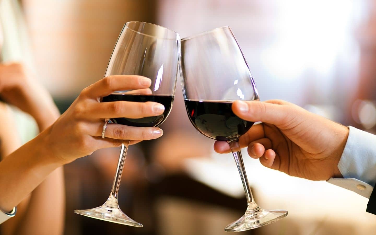 couple toasting with goblets of red wine