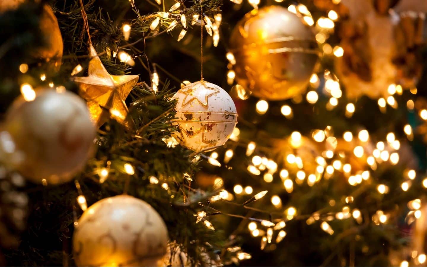 yellow lights with white ornaments on a christmas tree